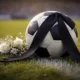 Pallone da calcio listato a lutto con un mazzo di fiori sul campo